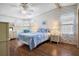 Relaxing bedroom features a comfortable bed, side tables with lamps, ceiling fan and wood-look laminate flooring at 6711 Canterbury Ne Dr, Winter Haven, FL 33881