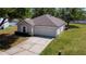 Aerial view of the single-story home with a large front yard and attached garage at 7316 Hunters Greene Cir, Lakeland, FL 33810