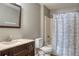 This bathroom features a dark wood vanity with a beige countertop and shower with a decorative curtain at 7316 Hunters Greene Cir, Lakeland, FL 33810