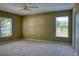 Spacious bedroom featuring two windows, carpeted flooring, and a ceiling fan at 7316 Hunters Greene Cir, Lakeland, FL 33810