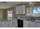 The kitchen features granite countertops, a stainless sink, white cabinets, and backyard access at 7316 Hunters Greene Cir, Lakeland, FL 33810