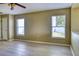 A spacious living room with two windows and a view of the kitchen at 7316 Hunters Greene Cir, Lakeland, FL 33810