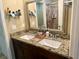 Bathroom featuring granite counters, dual sinks, framed mirror, and tiled walk-in shower at 74 N Oak Ave, Umatilla, FL 32784