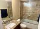 Well-lit bathroom with granite countertop vanity and shower over tub with glass doors at 74 N Oak Ave, Umatilla, FL 32784