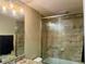 Tiled bathroom with granite countertop vanity and shower over tub with glass doors at 74 N Oak Ave, Umatilla, FL 32784