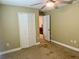 Bedroom features carpet floor, ceiling fan, closet, and access to the kitchen at 74 N Oak Ave, Umatilla, FL 32784