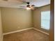 Bedroom with neutral carpet, ceiling fan, and window providing natural light at 74 N Oak Ave, Umatilla, FL 32784