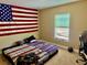 Bedroom with carpet floors, American flag wall decor, and window with blinds at 74 N Oak Ave, Umatilla, FL 32784