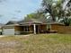 Charming single-story home featuring a well-manicured lawn and an American flag at 74 N Oak Ave, Umatilla, FL 32784