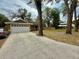 Charming single-story home featuring a well-manicured lawn and a concrete driveway at 74 N Oak Ave, Umatilla, FL 32784