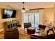 Inviting living room with a large leather sofa, comfortable seating, and sliding glass doors at 74 N Oak Ave, Umatilla, FL 32784