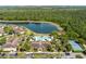 Aerial view highlighting a pool, clubhouse, and picturesque lake within the community at 7526 Pellham Way, Kissimmee, FL 34747