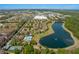 An aerial view of a community, showcasing a pool, tennis court, and a serene lake at 7526 Pellham Way, Kissimmee, FL 34747