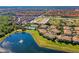An aerial view captures a beautiful lake and community, highlighting its pool and lush landscaping at 7526 Pellham Way, Kissimmee, FL 34747