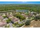 Breathtaking aerial view of townhomes near a tranquil lake and pool, highlighting the community's prime location and amenities at 7526 Pellham Way, Kissimmee, FL 34747