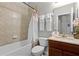 Cozy bathroom featuring a shower-tub combination with tile surround and a vanity with a solid surface counter at 7526 Pellham Way, Kissimmee, FL 34747
