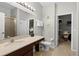 Bright bathroom featuring tile floors, vanity with a large mirror, and walk-in closet at 7526 Pellham Way, Kissimmee, FL 34747