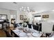 Elegant dining area with a chandelier, set table, and seamless flow into the living room, perfect for gatherings at 7526 Pellham Way, Kissimmee, FL 34747