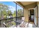 Enjoy the outdoors on this screened patio with a cozy table set, boasting views of lush tropical foliage and bright blue sky at 7526 Pellham Way, Kissimmee, FL 34747