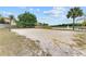 A sand volleyball court with net, surrounded by green grass and a scenic pond with a fountain at 7526 Pellham Way, Kissimmee, FL 34747