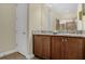 Bathroom features dual sinks with granite countertops, wood cabinets, and a separate shower at 7615 Brookhurst Ln, Kissimmee, FL 34747