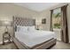Comfortable bedroom featuring a tufted headboard, soft carpet, and a window view to the outside at 7615 Brookhurst Ln, Kissimmee, FL 34747
