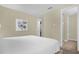 Bedroom with neutral walls has white linens, a painting and multiple doors leading to closet and bathroom at 7615 Brookhurst Ln, Kissimmee, FL 34747