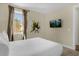 Inviting bedroom with a large window, a mounted TV, and neutral decor at 7615 Brookhurst Ln, Kissimmee, FL 34747