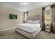 The main bedroom boasts a tufted headboard, large windows with curtains, and side tables with lamps at 7615 Brookhurst Ln, Kissimmee, FL 34747