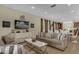 Open-concept living room flows into dining area and kitchen, offering comfortable seating and modern decor at 7615 Brookhurst Ln, Kissimmee, FL 34747