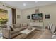 Cozy living room featuring comfortable couches, stylish decor, and a sliding glass door to outdoor space at 7615 Brookhurst Ln, Kissimmee, FL 34747