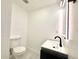A modern half bathroom features a sleek sink with a black faucet and a bright, illuminated mirror at 817 Clay Blvd, Eustis, FL 32726