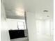 Bright entryway showcasing neutral walls, plank flooring, and an adjacent kitchen with black cabinets and stainless steel appliances at 817 Clay Blvd, Eustis, FL 32726