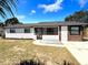 Charming single-story home featuring a brick facade, screened front porch, and modern black framed windows at 817 Clay Blvd, Eustis, FL 32726
