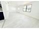 Bright and open living room featuring plank flooring, neutral paint, with views of the back entrance and kitchen area at 817 Clay Blvd, Eustis, FL 32726
