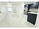 Open living space with views into the kitchen, stainless steel appliances, and bright white plank flooring throughout the room at 817 Clay Blvd, Eustis, FL 32726