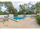 Community pool surrounded by mature landscaping with lounge chairs and tables for relaxing and enjoying the sunshine at 845 Orchid Springs Dr, Winter Haven, FL 33884