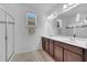Spacious bathroom featuring double sinks, dark cabinetry, and a glass-enclosed shower at 8498 Powder Ridge Trl, Windermere, FL 34786