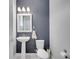 Modern half bathroom features a pedestal sink and stylish blue wallpaper at 8498 Powder Ridge Trl, Windermere, FL 34786