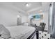 Neutral bedroom with hardwood floors, large TV, and sitting area with reading chair at 8498 Powder Ridge Trl, Windermere, FL 34786