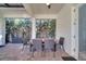 Charming covered patio features brick pavers, comfortable seating, and lush greenery for serene outdoor living at 8498 Powder Ridge Trl, Windermere, FL 34786