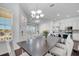 Bright dining area featuring white wooden chairs, chandelier and natural light, seamlessly connected to the kitchen at 8498 Powder Ridge Trl, Windermere, FL 34786
