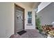 Charming gray front door with a decorative wreath, complemented by brick pavers and lush landscaping at 8498 Powder Ridge Trl, Windermere, FL 34786