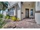 Inviting front porch features brick pavers, lush landscaping, and a decorative wreath on the gray front door at 8498 Powder Ridge Trl, Windermere, FL 34786