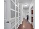 Hallway with wood floors, neutral paint, and a door that has glass blocks for natural light at 8498 Powder Ridge Trl, Windermere, FL 34786