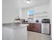 Functional kitchenette featuring granite countertops, dark wood cabinets, and stainless-steel appliances at 8498 Powder Ridge Trl, Windermere, FL 34786