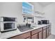Bright kitchenette with granite countertops, wood cabinets, stainless steel appliances, and organized shelving at 8498 Powder Ridge Trl, Windermere, FL 34786