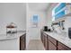 Well-lit kitchenette featuring granite countertops, wood cabinets, and modern appliances with a window at 8498 Powder Ridge Trl, Windermere, FL 34786