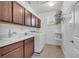 Bright laundry room with washer, sink, and overhead cabinets for ample storage at 8498 Powder Ridge Trl, Windermere, FL 34786