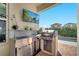 Outdoor kitchen with stainless steel appliances, a built-in grill, a sink, and a mounted TV for ultimate outdoor entertaining at 8498 Powder Ridge Trl, Windermere, FL 34786